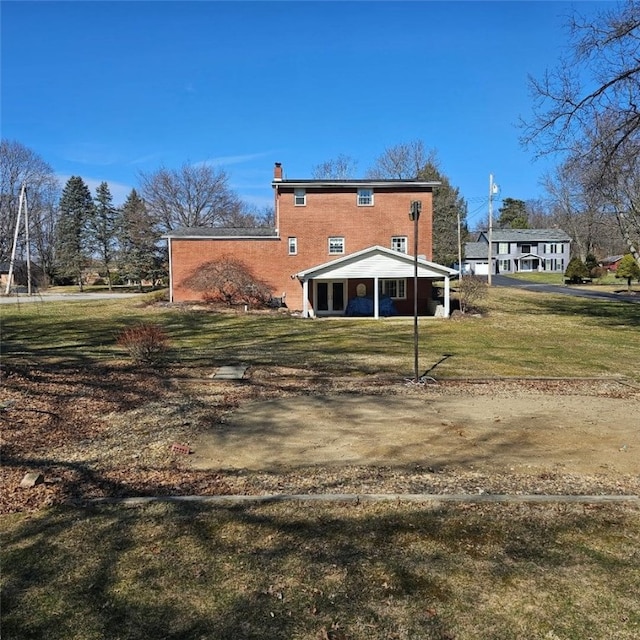 back of house featuring a chimney and a lawn