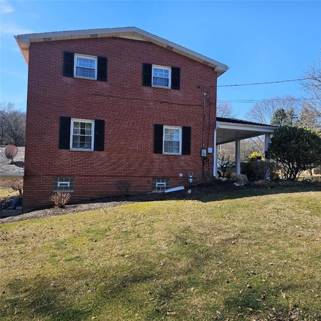 view of property exterior with a carport, brick siding, and a yard