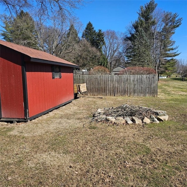 view of yard with an outdoor structure, a storage shed, and fence