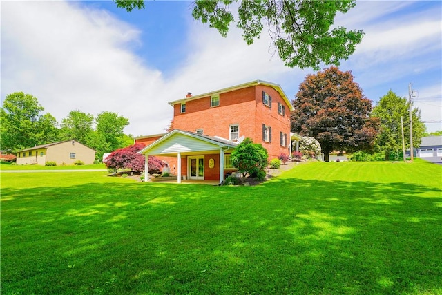 127 Stickle Rd, Chippewa Twp, PA 15010 - rear view of house featuring french doors, a yard, a chimney, and brick siding