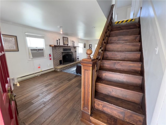 staircase with hardwood / wood-style flooring, a fireplace, baseboard heating, and cooling unit