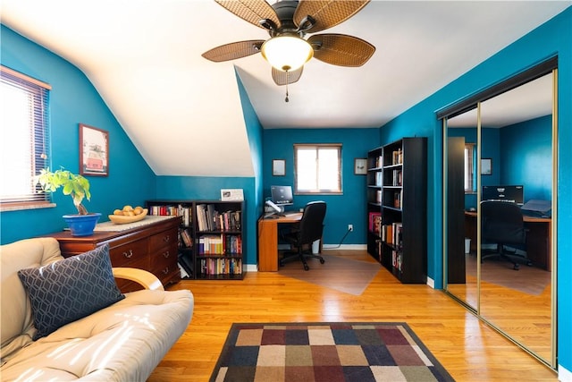 office area with a ceiling fan, lofted ceiling, baseboards, and wood finished floors