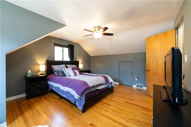 bedroom with light wood finished floors, lofted ceiling, visible vents, ceiling fan, and baseboards