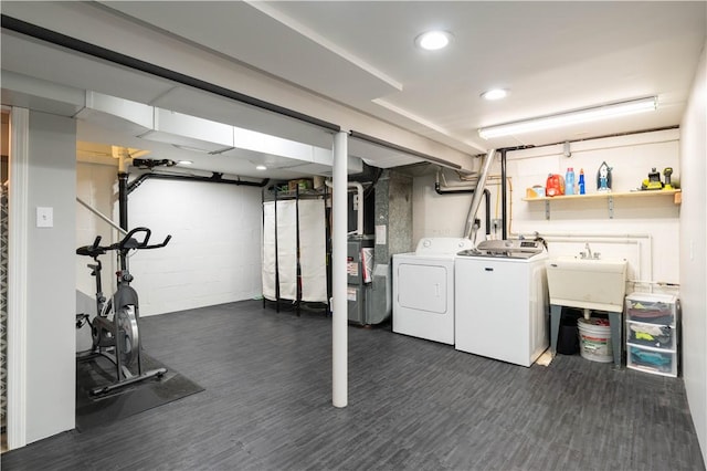 interior space featuring dark wood-style floors, washer and dryer, a sink, and heating unit