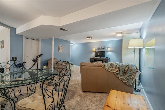 living area featuring visible vents, light carpet, and baseboards