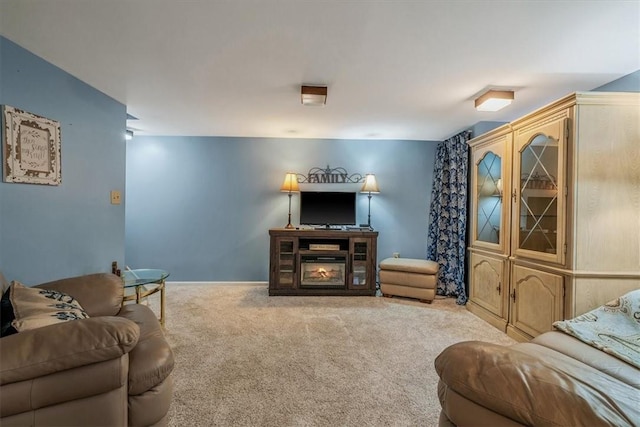 living area with carpet, baseboards, and a glass covered fireplace