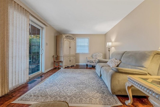 living room featuring visible vents, baseboards, and dark wood-style flooring