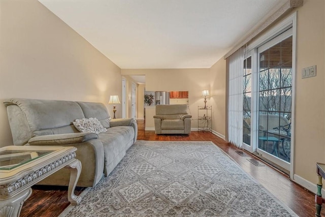 living area with baseboards and wood finished floors