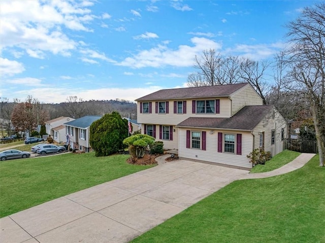 colonial home featuring a shingled roof, fence, a front lawn, and concrete driveway