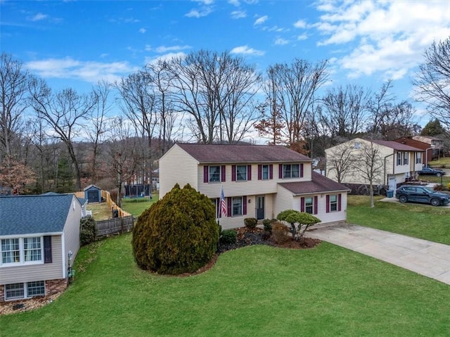 view of front of home with concrete driveway, a front lawn, and an outdoor structure