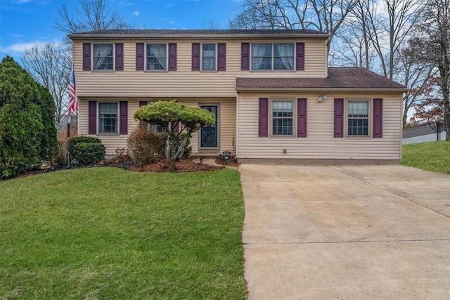 view of front of home featuring driveway and a front lawn