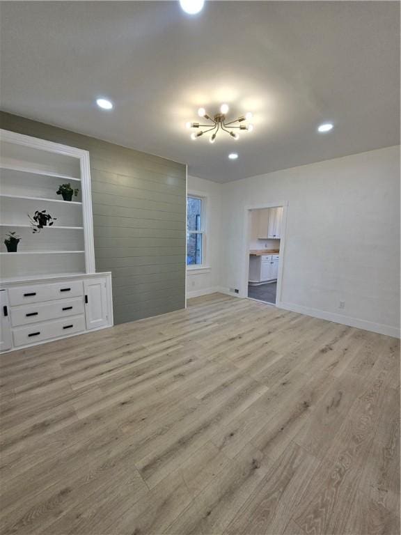 unfurnished living room with light wood-type flooring, baseboards, and recessed lighting