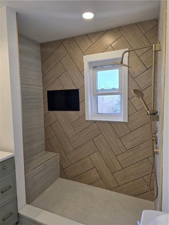 bathroom featuring tiled shower and vanity