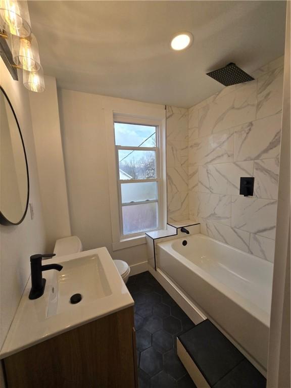 full bath with baseboards, shower / bathing tub combination, vanity, and toilet