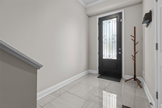 foyer entrance featuring ornamental molding and baseboards