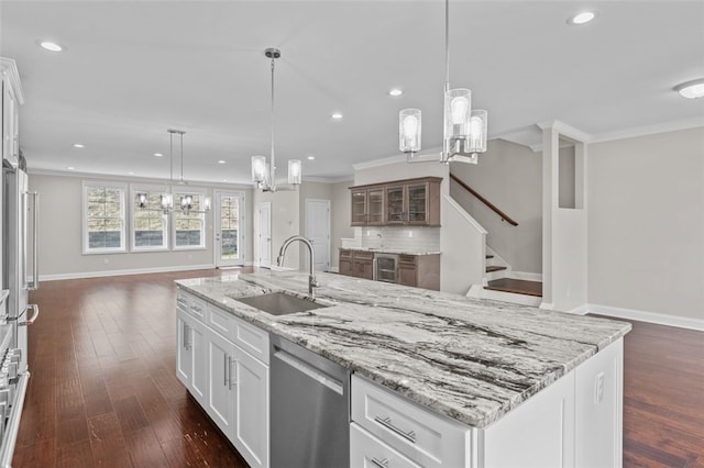 kitchen featuring a notable chandelier, a sink, stainless steel dishwasher, decorative backsplash, and crown molding