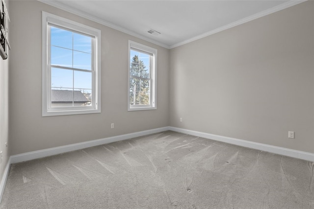 carpeted spare room featuring ornamental molding, visible vents, and baseboards