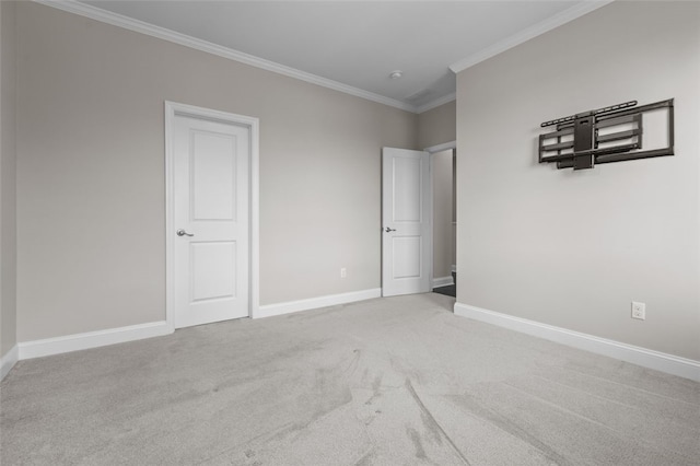 unfurnished bedroom featuring baseboards, carpet, and crown molding