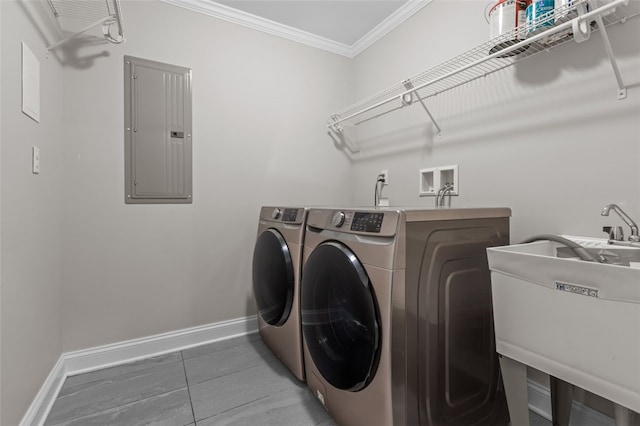 laundry room with ornamental molding, washing machine and dryer, a sink, laundry area, and electric panel