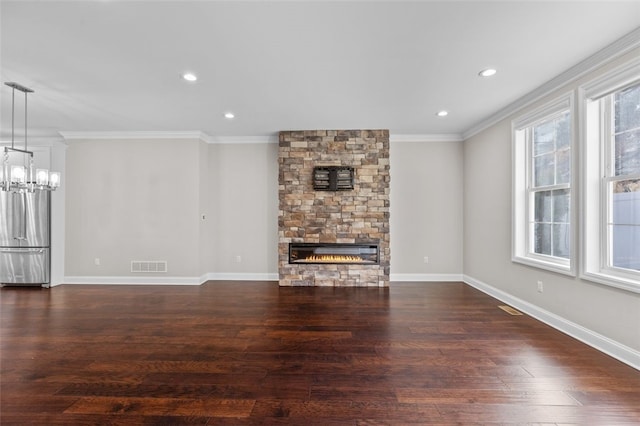 unfurnished living room with dark wood-style flooring, a fireplace, visible vents, and crown molding