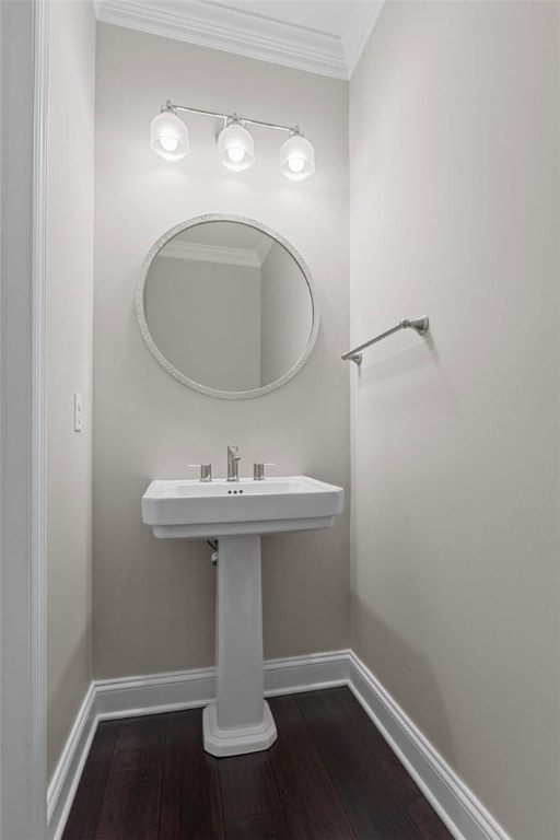 bathroom with ornamental molding, hardwood / wood-style flooring, and baseboards