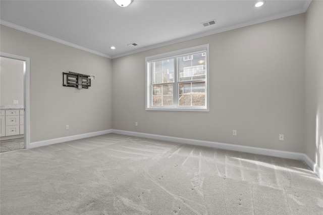 unfurnished room featuring ornamental molding, light carpet, visible vents, and baseboards