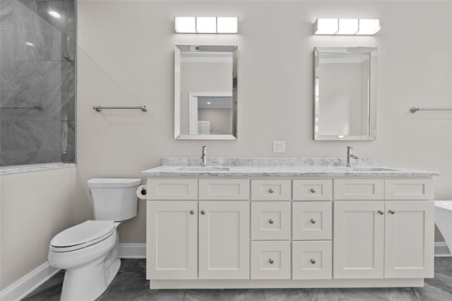 full bathroom featuring double vanity, toilet, a sink, a tile shower, and baseboards