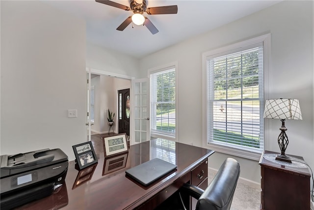 office space featuring ceiling fan and baseboards