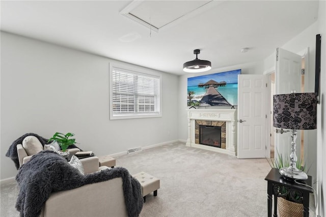 living room with attic access, visible vents, baseboards, light colored carpet, and a tile fireplace