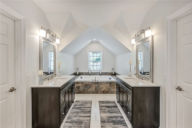 full bath with a sink, vaulted ceiling, two vanities, and a garden tub