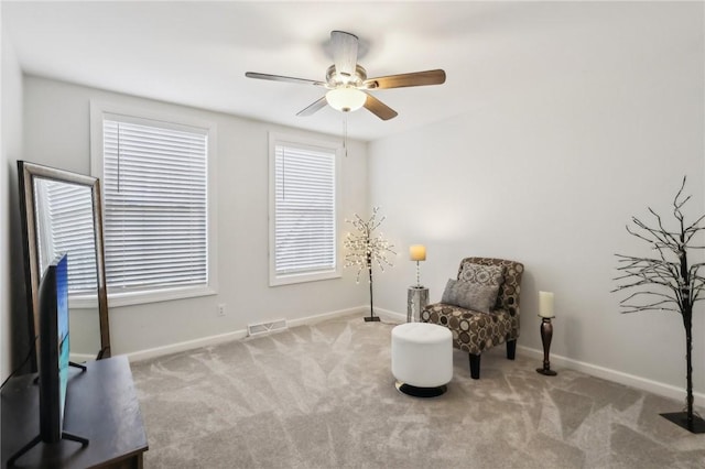 living area with carpet, visible vents, ceiling fan, and baseboards