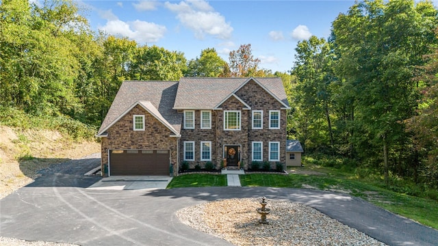 colonial house with a garage, driveway, and a front lawn