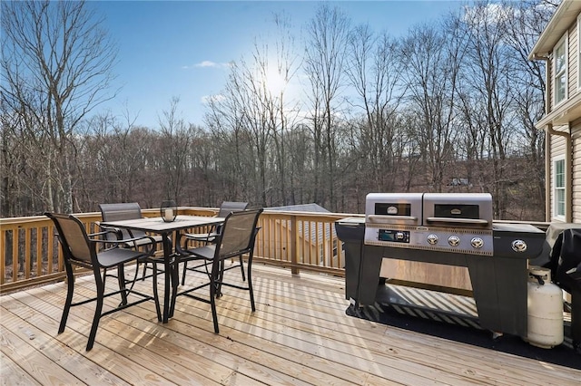 wooden terrace featuring grilling area and outdoor dining space