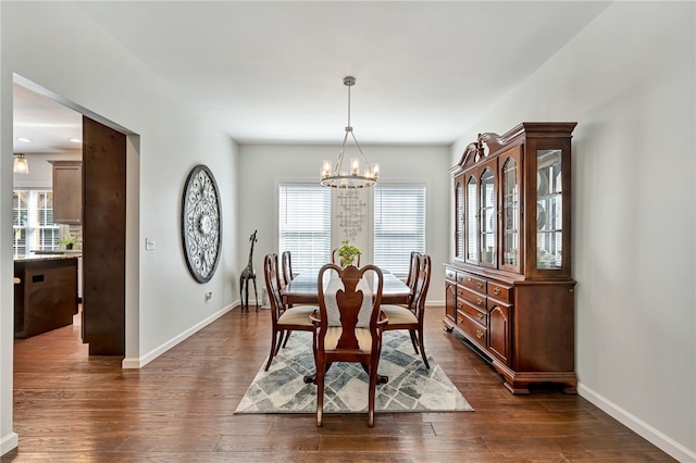 dining area with baseboards, dark wood-style flooring, and a notable chandelier