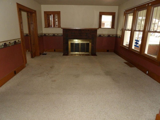 living room featuring light carpet, wainscoting, and a brick fireplace