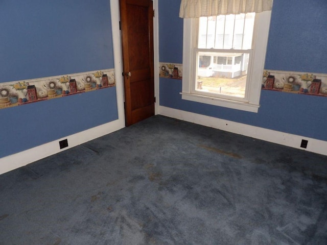 spare room featuring dark carpet