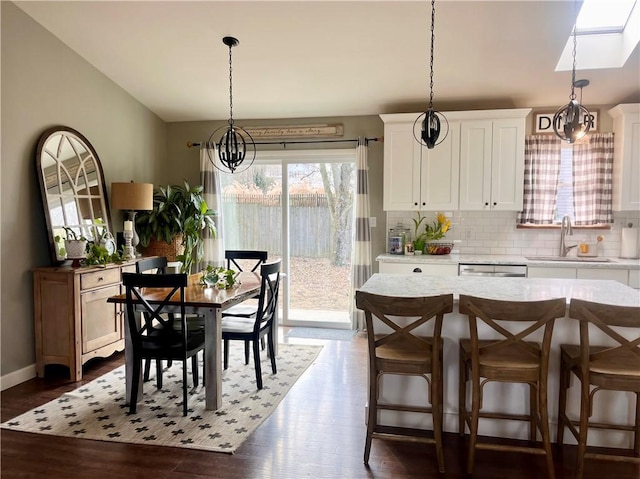 dining space with dark wood-style floors, baseboards, and an inviting chandelier