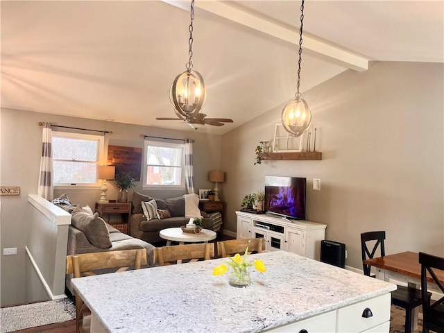 dining space featuring vaulted ceiling with beams, baseboards, and a ceiling fan