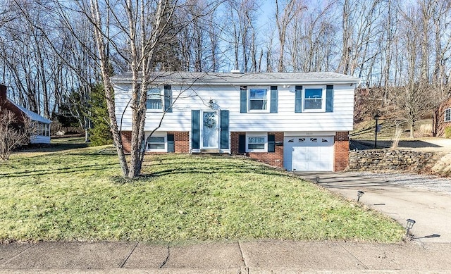 split foyer home featuring an attached garage, brick siding, driveway, and a front yard