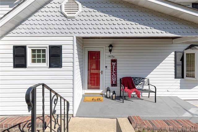 view of exterior entry featuring visible vents and a porch