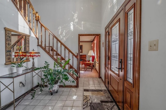 entryway featuring light tile patterned floors, a high ceiling, stairway, and french doors