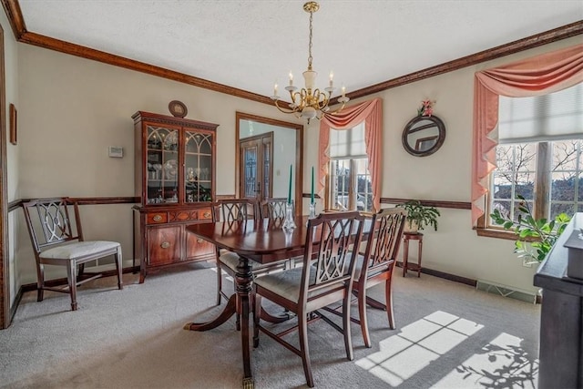 dining space featuring carpet, crown molding, baseboards, and an inviting chandelier