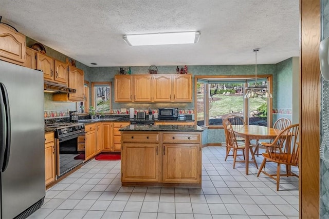 kitchen featuring a textured ceiling, under cabinet range hood, hanging light fixtures, a center island, and black appliances