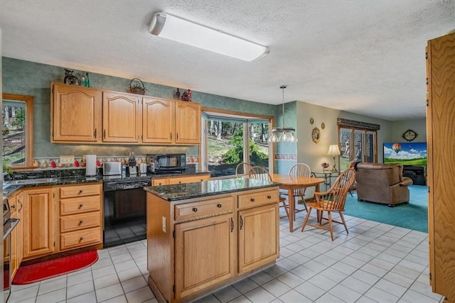 kitchen featuring pendant lighting, light tile patterned flooring, a kitchen island, dark stone countertops, and black appliances