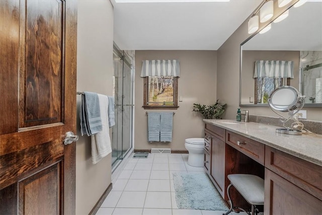 full bathroom featuring toilet, a shower stall, vanity, and tile patterned floors