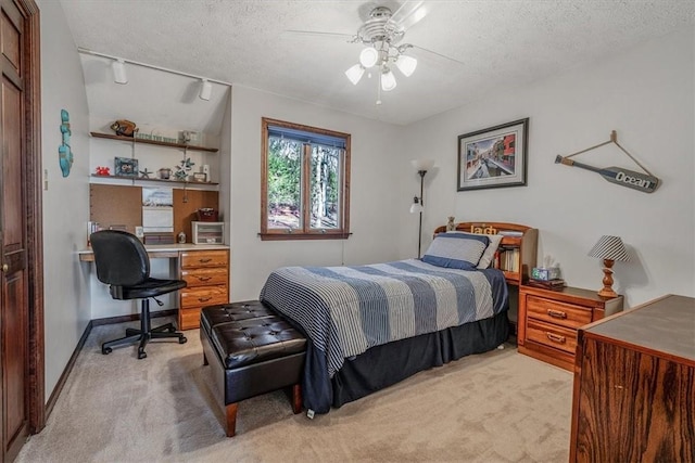 bedroom featuring a ceiling fan, light carpet, a textured ceiling, and baseboards