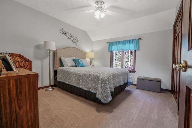 bedroom with lofted ceiling, ceiling fan, a textured ceiling, light carpet, and baseboards