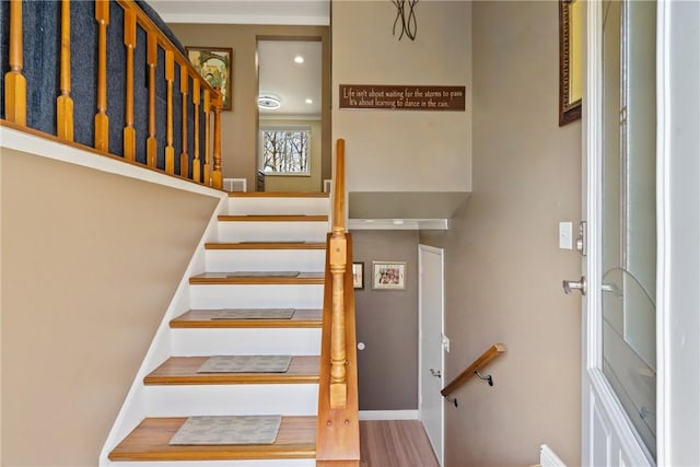 stairway with wood finished floors and baseboards