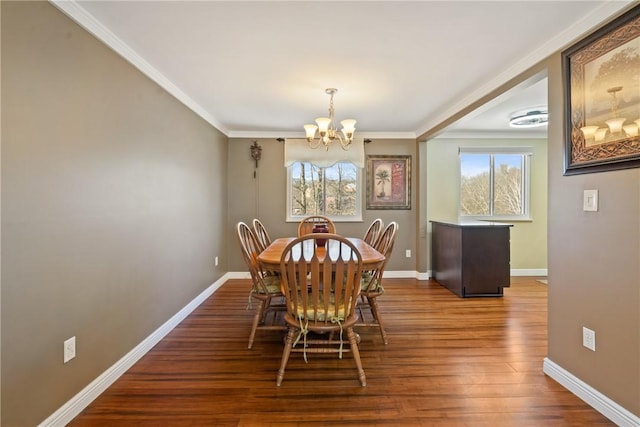 dining room with baseboards, crown molding, a chandelier, and wood finished floors