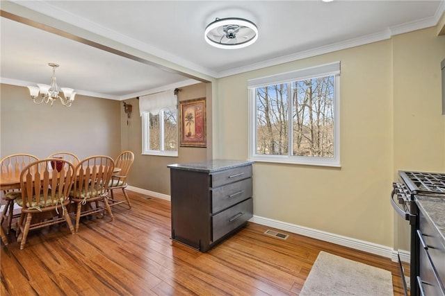 dining room with ornamental molding, a wealth of natural light, and wood finished floors